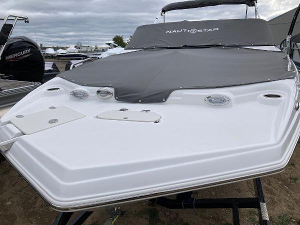 Slide: The Image of 2024 NauticStar 223 DC boat with cover on trailer. - 2