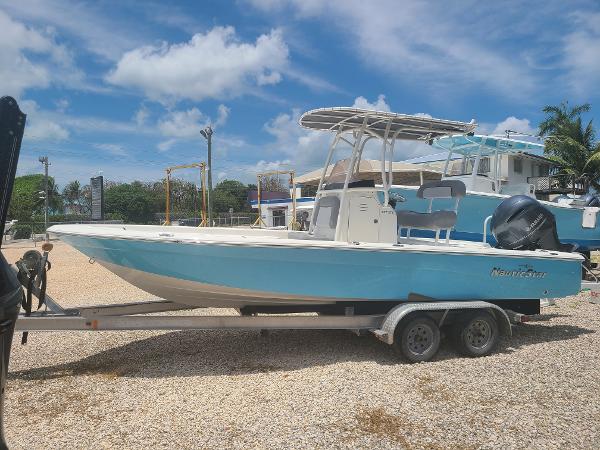 Slide: The Image of 2022 NauticStar 227XTS boat on trailer under blue sky. - 2