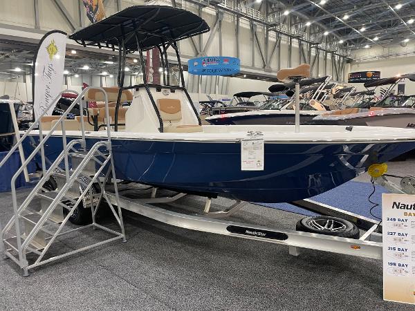 Slide: The Image of 2023 NauticStar 227 XTS boat on display at an indoor exhibition. - 1