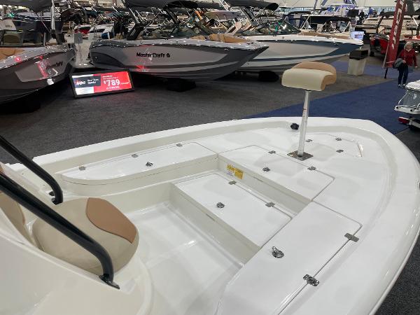 Slide: The Image of 2023 NauticStar 227 XTS boat interior at a showroom, featuring seating and storage compartments. - 3