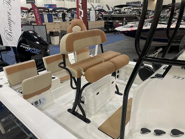 Slide: The Image of 2023 NauticStar 227 XTS boat interior with tan and white seating, showcased at a boat exhibition. - 4