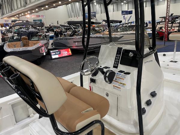 Slide: The Image of 2023 NauticStar 227 XTS boat interior at a boat show, featuring helm and seating. - 5