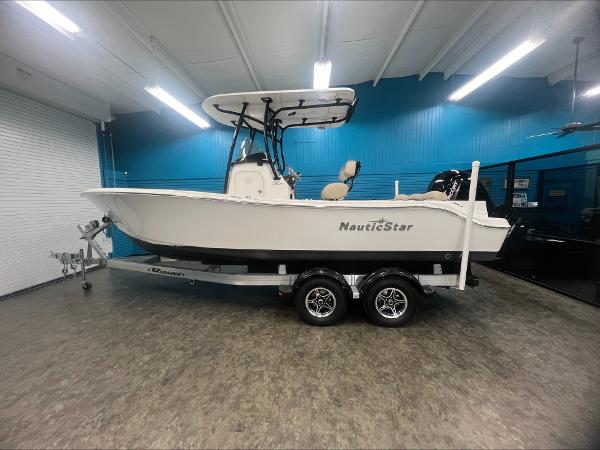 Slide: The Image of 2023 NauticStar 2302 Legacy boat on a trailer in a showroom. - 0
