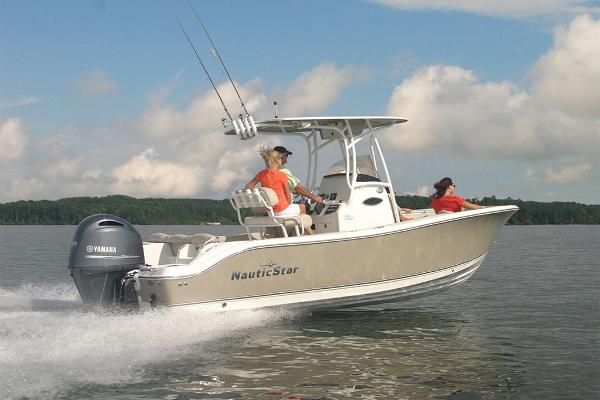 Slide: The Image of 2023 NauticStar 2302 Legacy boat cruising on a lake. - 12