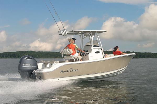 Slide: The Image of 2023 NauticStar 2302 Legacy boat cruising on a lake with two passengers. - 13