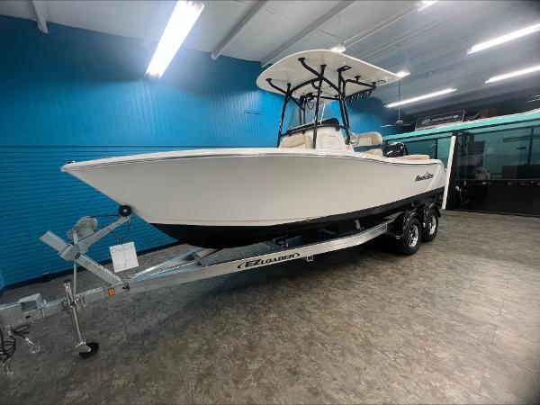 Slide: The Image of 2023 NauticStar 2302 Legacy boat on EZ Loader trailer in showroom. - 2