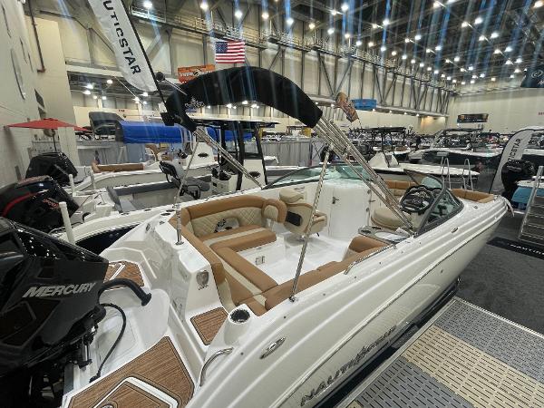 Slide: The Image of 2024 NauticStar 243 DC boat on display at an indoor boat show. - 2
