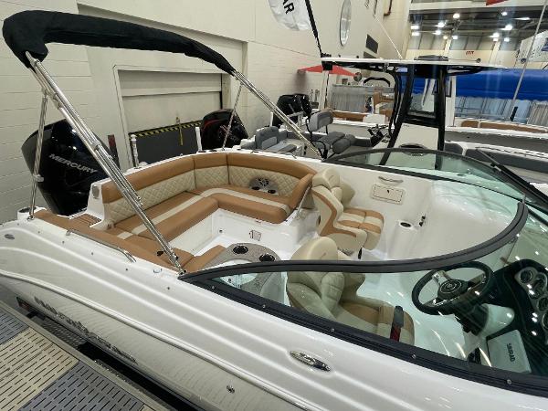 Slide: The Image of 2024 NauticStar 243 DC boat interior with tan and white seating at a boat show. - 3