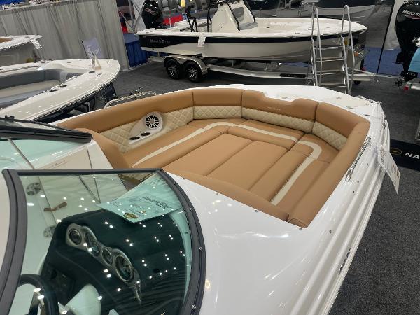 Slide: The Image of 2024 NauticStar 243 DC boat with spacious tan seating at a boat show. - 4