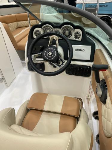 Slide: The Image of 2024 NauticStar 243 DC boat dashboard with steering wheel and Simrad display. - 6