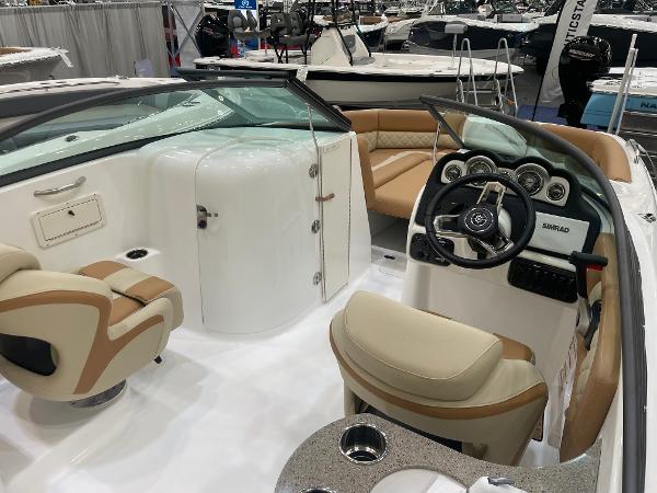 Slide: The Image of 2024 NauticStar 243 DC boat interior with beige seating and modern dashboard. - 7