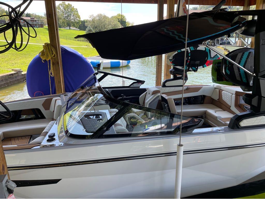 Slide: The Image of 2023 Nautique G23 boat docked with wakeboards and lake view. - 15