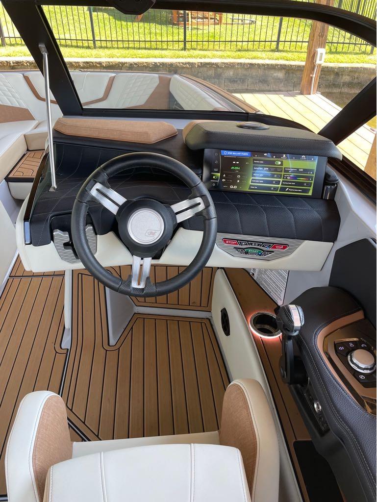 Slide: The Image of 2023 Nautique G23 boat cockpit with steering wheel and digital display. - 16