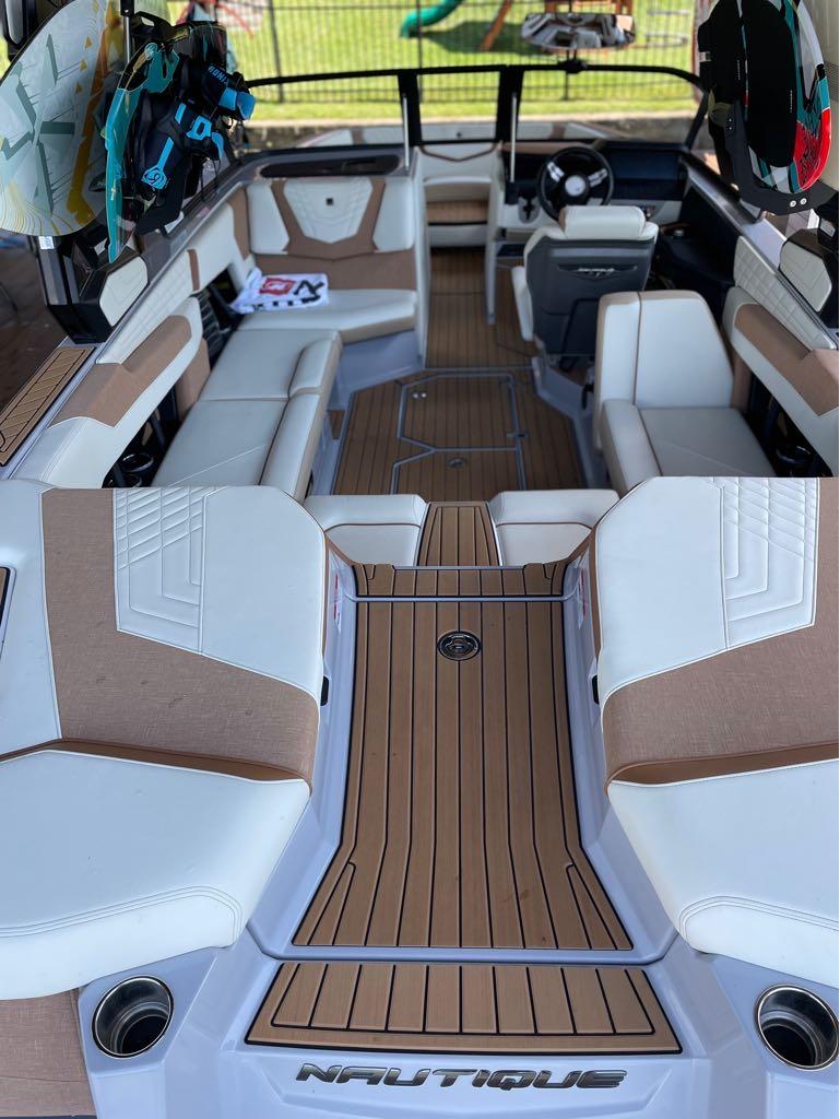 Slide: The Image of 2023 Nautique G23 boat interior with luxurious seating and wakeboards. - 17