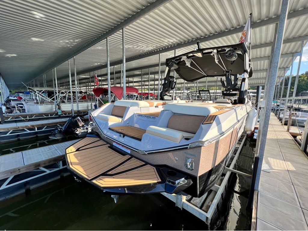 Slide: The Image of 2023 Nautique G23 boat docked in a covered marina. - 18