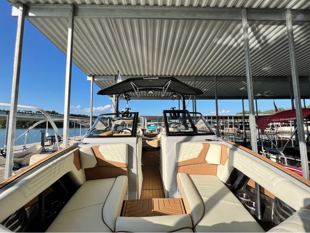 Slide: The Image of 2023 Nautique G23 boat interior at a marina under a metal canopy. - 24