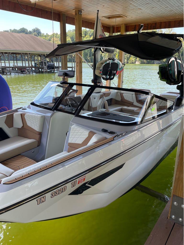 Slide: The Image of 2023 Nautique G23 boat docked in a covered marina on a lake. - 29