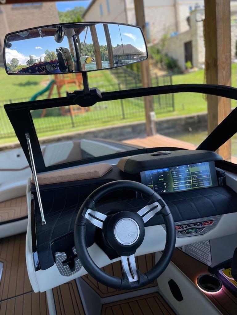 Slide: The Image of 2023 Nautique G23 boat dashboard with steering wheel and touchscreen display. - 30