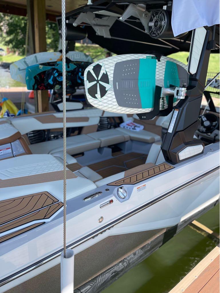 Slide: The Image of 2023 Nautique G23 boat with wakeboards docked on a sunny day. - 32