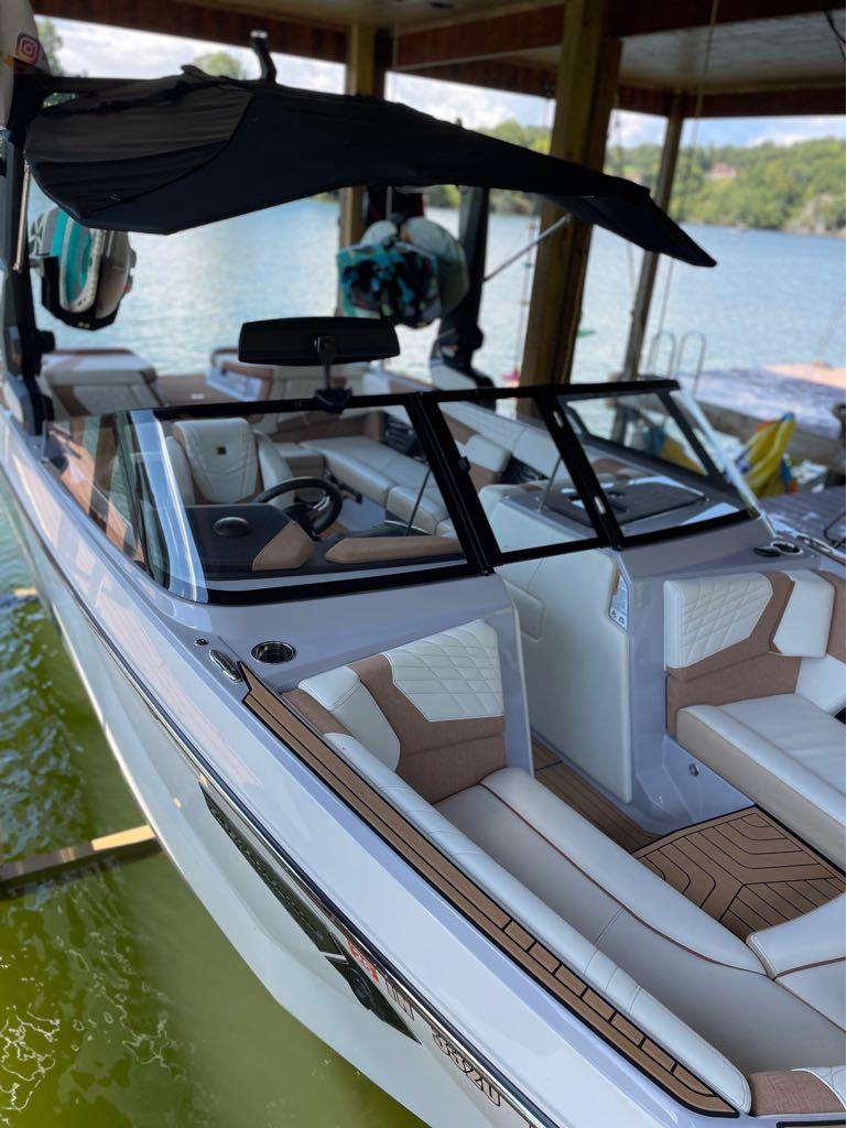 Slide: The Image of 2023 Nautique G23 boat with luxurious interior docked on a serene lake. - 4