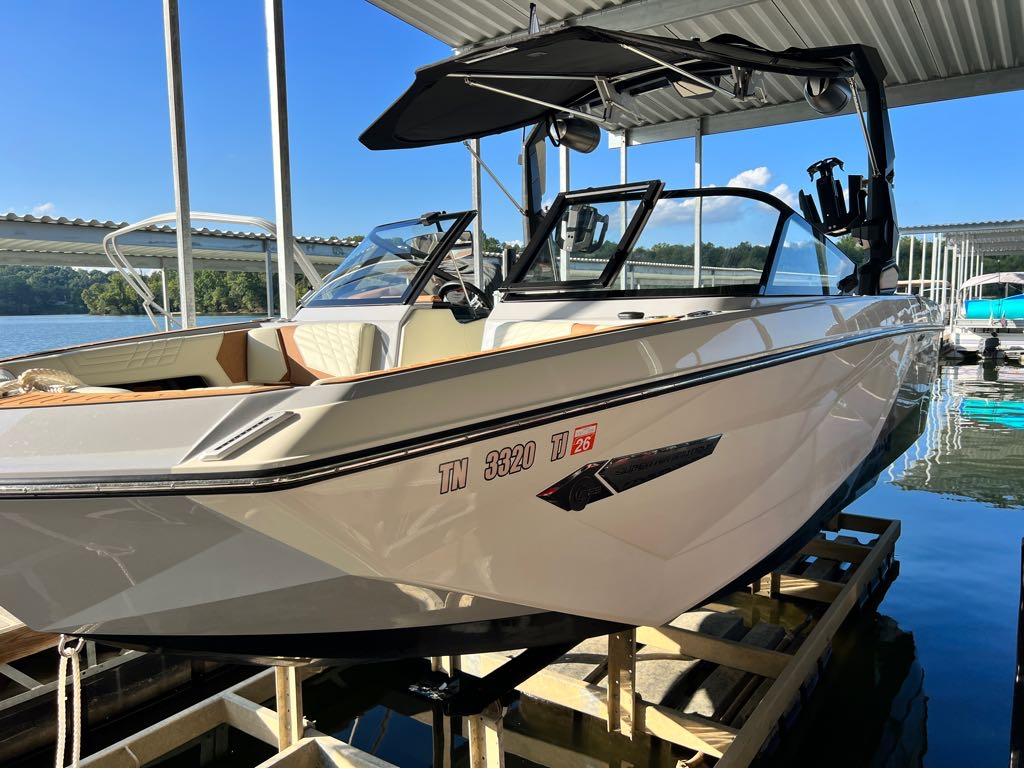 Slide: The Image of 2023 Nautique G23 boat docked under a covered marina. - 7