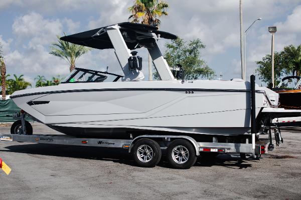 Slide: The Image of 2022 Nautique G25 boat on a trailer in a parking lot. - 1