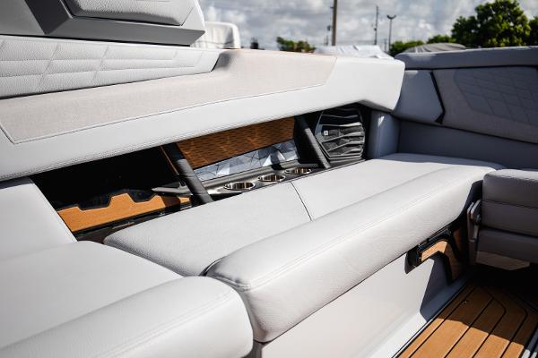 Slide: The Image of 2022 Nautique G25 boat interior with white leather seating and wood accents. - 11