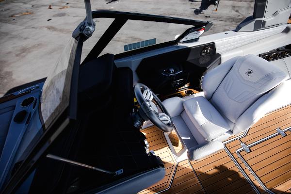 Slide: The Image of 2022 Nautique G25 boat interior with white captain's chair and wooden deck. - 15