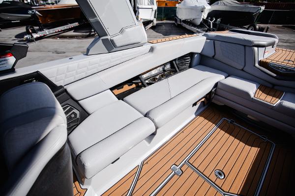Slide: The Image of 2022 Nautique G25 boat interior with luxurious seating and teak flooring. - 18
