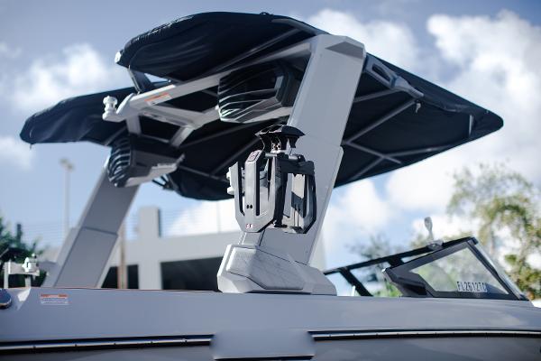 Slide: The Image of 2022 Nautique G25 boat with advanced wakeboard tower and bimini top. - 2