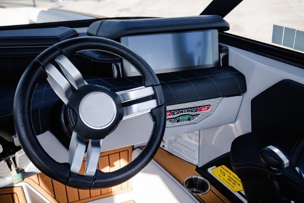 Slide: The Image of 2022 Nautique G25 boat dashboard with steering wheel and control panel. - 20