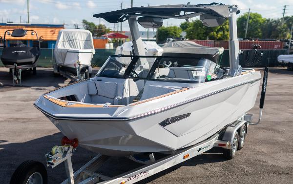 Slide: The Image of 2022 Nautique G25 boat on a trailer in a marina. - 29