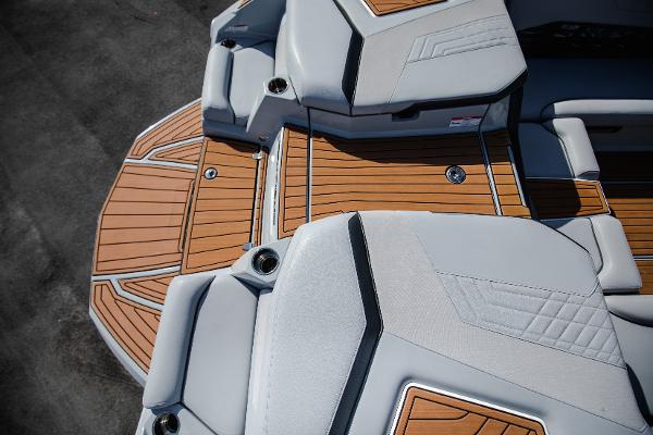Slide: The Image of 2022 Nautique G25 boat interior with teak flooring and cushioned seating. - 30