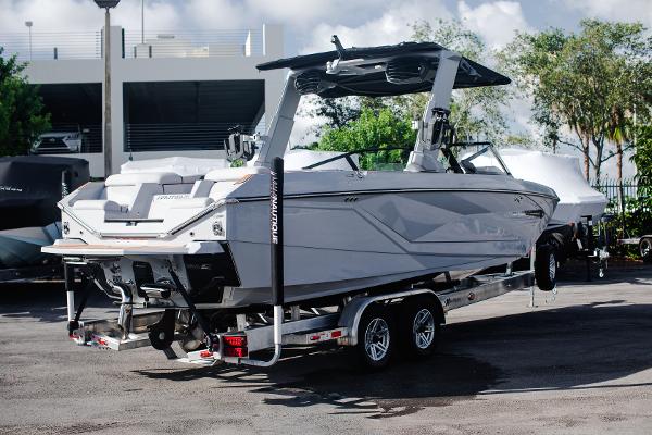 Slide: The Image of 2022 Nautique G25 boat on a trailer in a parking lot. - 33