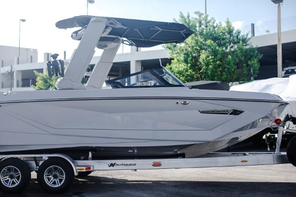 Slide: The Image of 2022 Nautique G25 boat on a trailer, parked outdoors. - 34