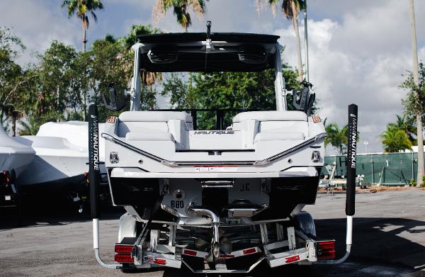 Slide: The Image of 2022 Nautique G25 boat rear view with trailer in a marina. - 35