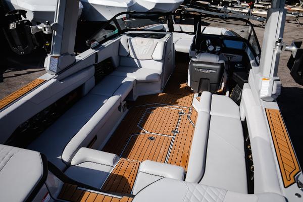 Slide: The Image of 2022 Nautique G25 boat interior with luxurious seating and teak flooring. - 9