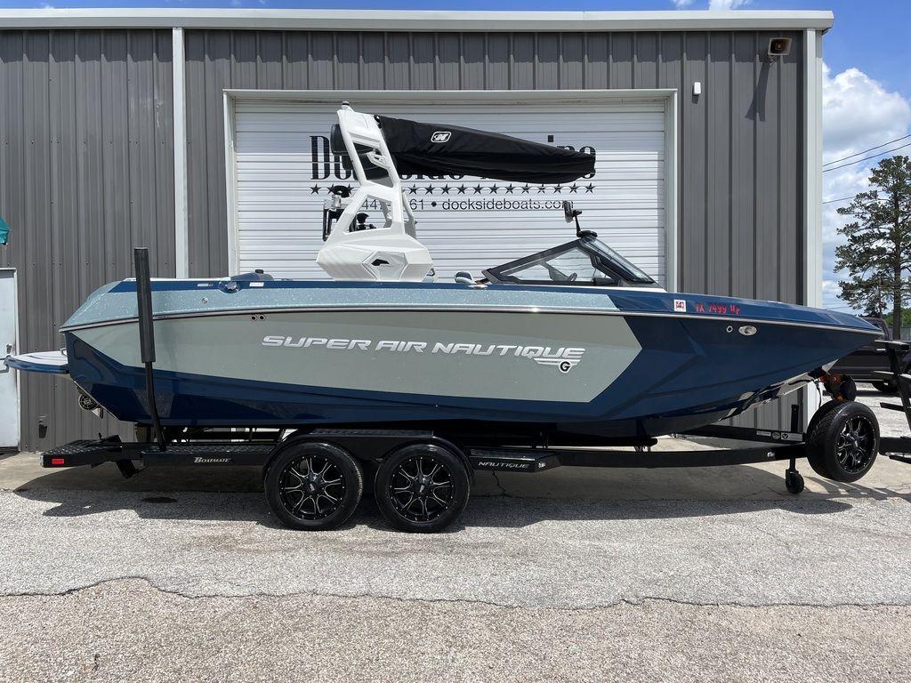 Slide: The Image of 2019 Nautique Super Air Nautique G23 boat on trailer outside a building. - 0