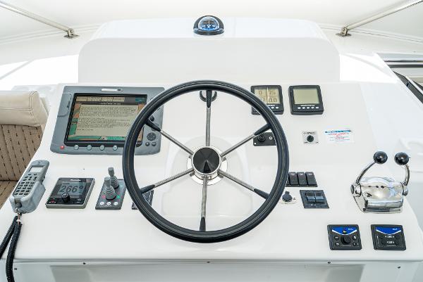 Slide: The Image of 2008 Navigator 62 Pilothouse helm with steering wheel and navigation controls. - 15