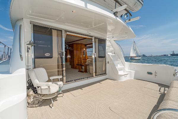 Slide: The Image of 2008 Navigator 62 Pilothouse yacht deck with open sliding doors, ocean view, and seating area. - 22