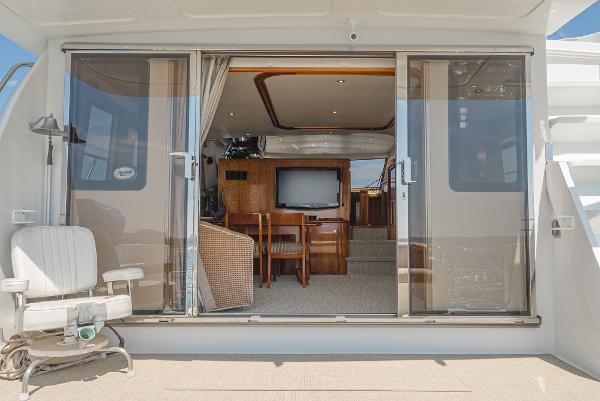 Slide: The Image of 2008 Navigator 62 Pilothouse yacht interior with sliding glass doors and seating area. - 23
