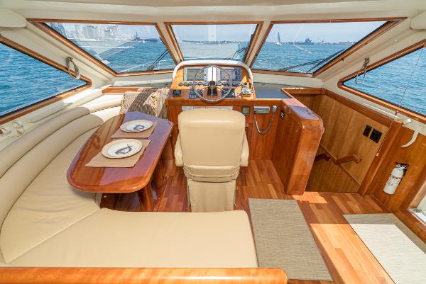 Slide: The Image of 2008 Navigator 62 Pilothouse interior with helm, dining area, and panoramic ocean views. - 38