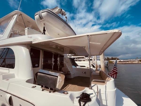 Slide: The Image of 2008 Navigator 62 Pilothouse yacht with American flag, docked under a blue sky. - 5