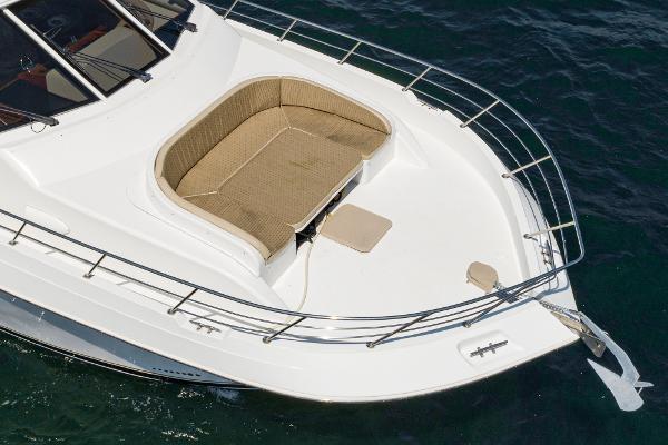 Slide: The Image of 2008 Navigator 62 Pilothouse yacht with cushioned seating on the deck, surrounded by ocean water. - 8