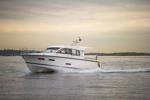 Slide: The Image of 2025 Nimbus 305 Coupe cruising on calm waters at sunset. - 0