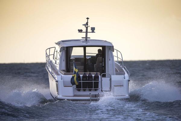 Slide: The Image of Nimbus 305 Coupe 2025 cruising on open water at sunset. - 1