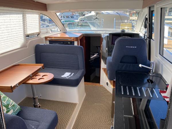 Slide: The Image of Interior of 2025 Nimbus 305 Coupe yacht with seating and navigation area. - 6