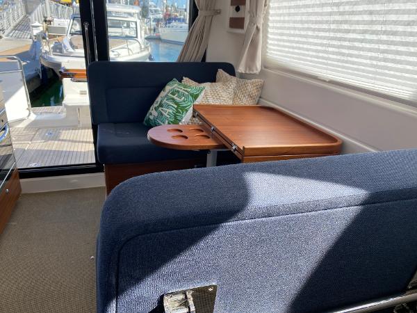 Slide: The Image of Interior of 2025 Nimbus 305 Coupe with blue seating and wooden table. - 8