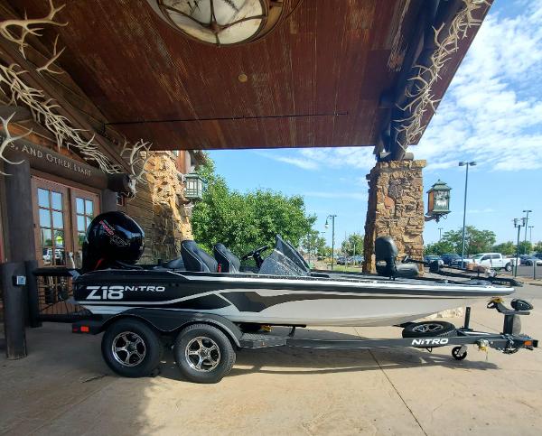 Slide: The Image of 2024 Nitro Z18 boat parked under a rustic wooden structure. - 1