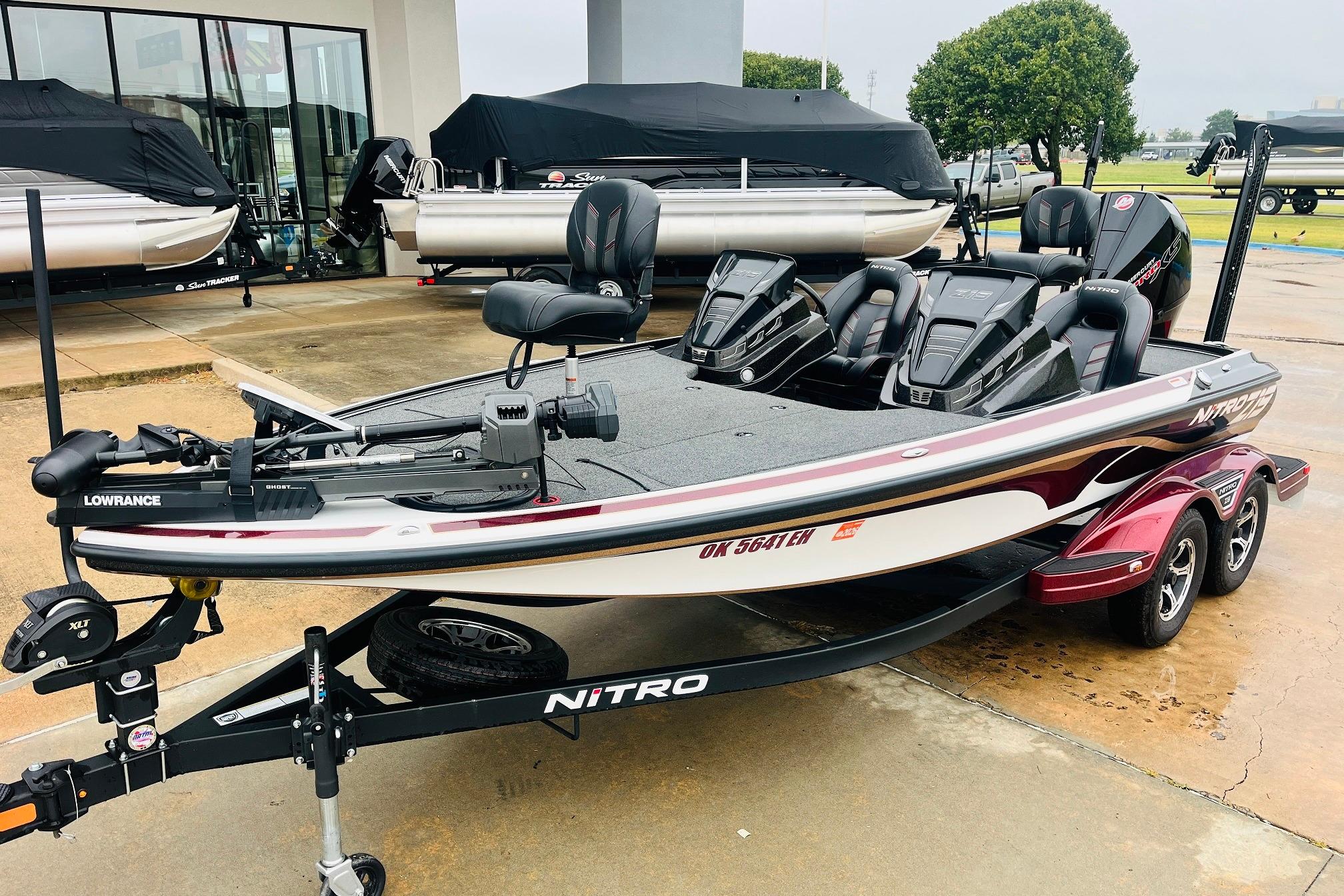 Slide: The Image of 2021 Nitro Z19 Pro fishing boat with trailer, featuring Lowrance equipment, parked outdoors. - 2
